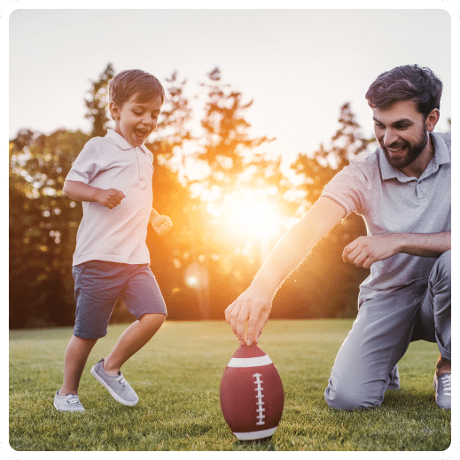 Father and son playing football together