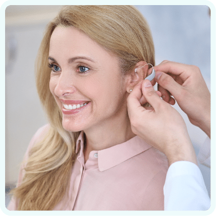 Woman getting a hearing aid fitted by an audiologist